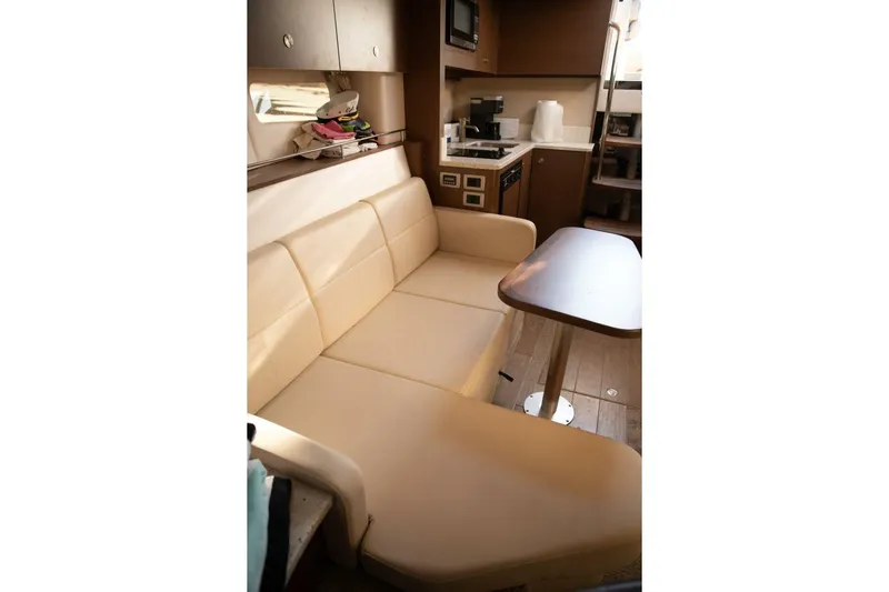  Yacht Photos Pics Interior of 2016 Sea Ray 350 Sundancer with beige seating and compact kitchen area.