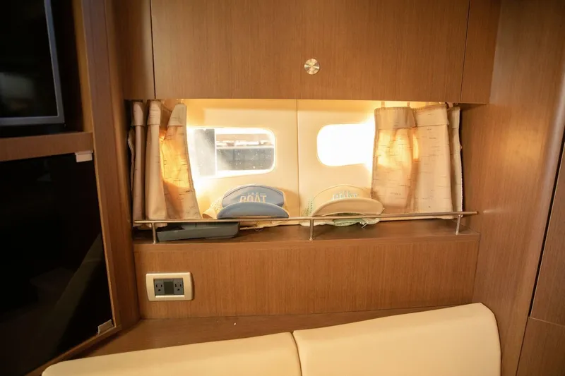  Yacht Photos Pics Interior of 2016 Sea Ray 350 Sundancer with window, curtains, and hats on shelf.