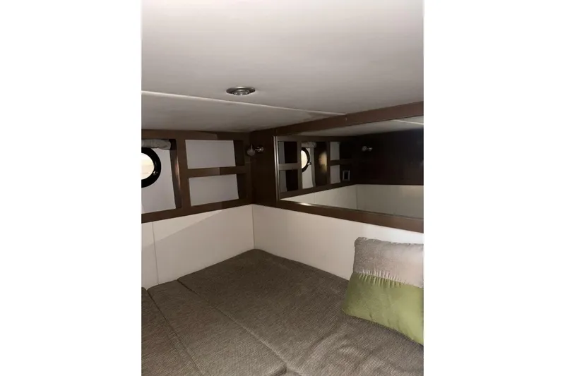  Yacht Photos Pics Interior cabin of 2016 Sea Ray 350 Sundancer with cozy bedding and porthole window.