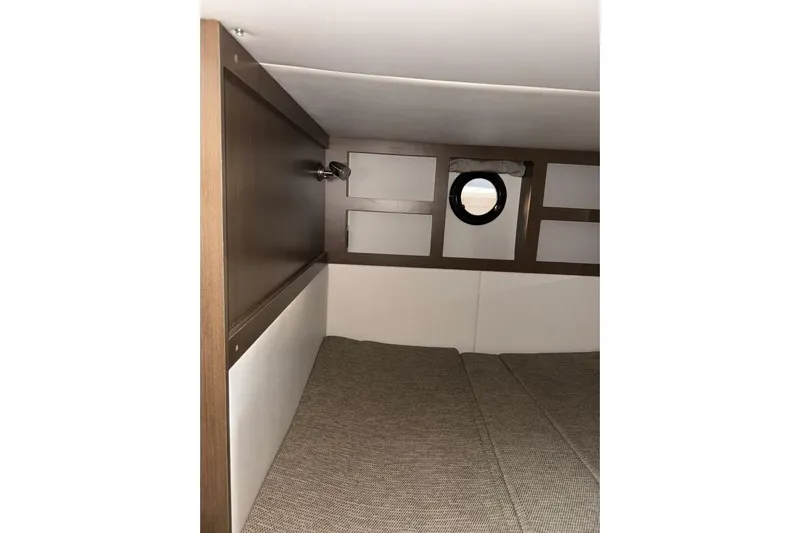  Yacht Photos Pics Interior cabin of 2016 Sea Ray 350 Sundancer with porthole and cozy bedding.