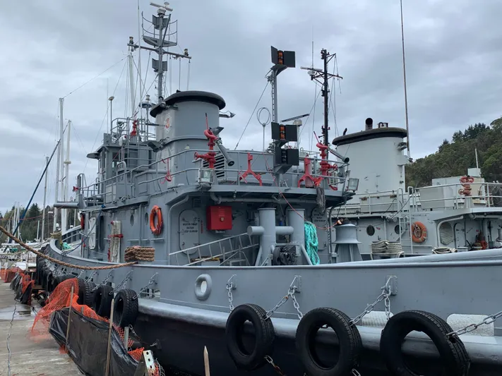  Yacht Photos Pics 1955 L-T 100 Steel Army Tugboat docked, showcasing its robust design and maritime equipment.