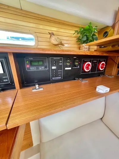  Yacht Photos Pics Control panel inside a 2017 Catalina 425 yacht, featuring wood accents and a small plant.