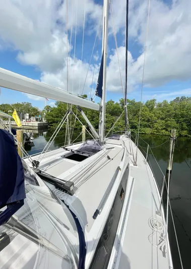  Yacht Photos Pics 2017 Catalina 425 sailboat docked, surrounded by lush greenery and blue sky.