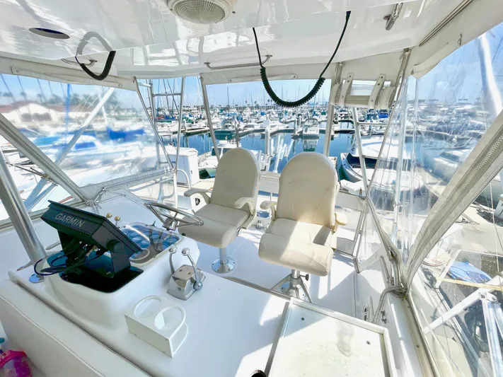 Aqua Ma'am Yacht Photos Pics 1986 Ocean Yachts 38 Super Sport cockpit with marina view, featuring helm and seating.