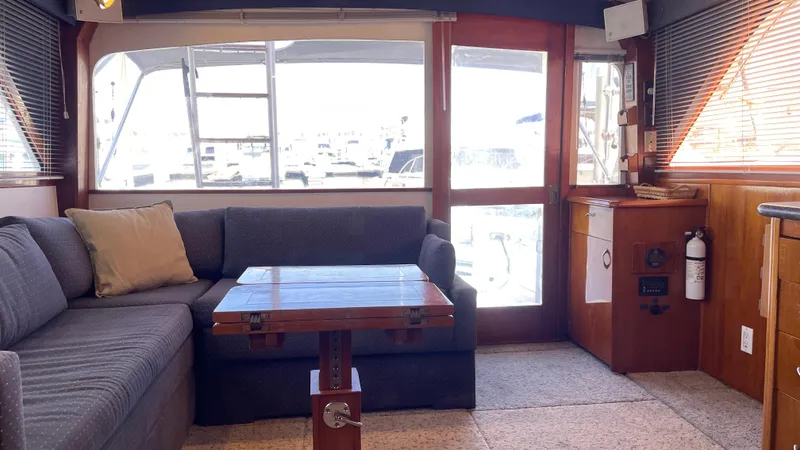 Aqua Ma'am Yacht Photos Pics Interior of 1986 Ocean Yachts 38 Super Sport with cozy seating and wooden table.