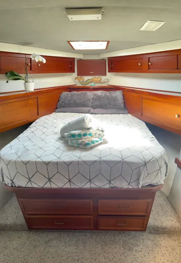 Aqua Ma'am Yacht Photos Pics 1986 Ocean Yachts 38 Super Sport cabin with bed, wooden cabinets, and natural light.