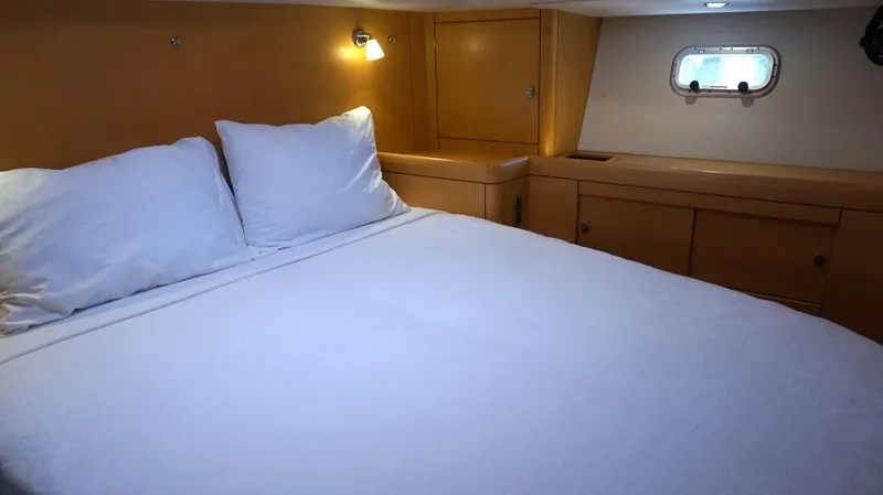 Dolce Vita Yacht Photos Pics Cozy bedroom interior of 2008 Oyster 46 yacht with wooden cabinetry and soft lighting.