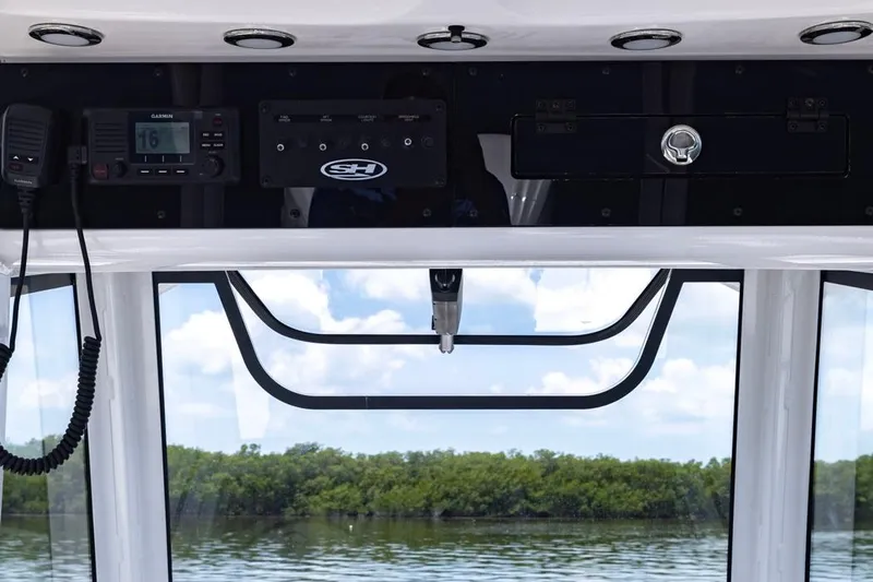  Yacht Photos Pics 2026 Sea Hunt Gamefish 30 dashboard with electronics, overlooking serene water and lush greenery.