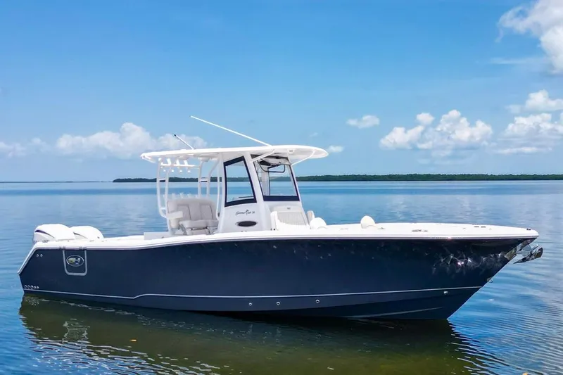  Yacht Photos Pics 2026 Sea Hunt Gamefish 30 Forward Seating boat on calm water under blue sky.