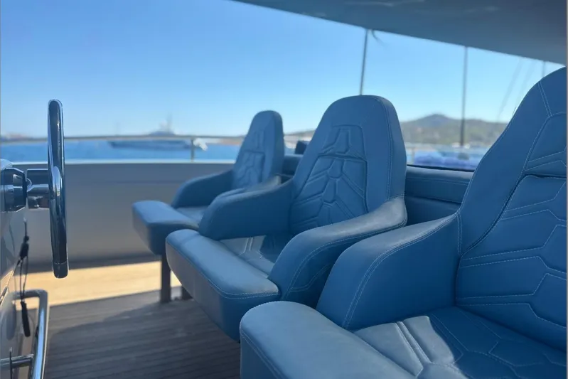 Deea II Yacht Photos Pics Luxury yacht seating on 2009 Cerri Cantieri Navali 102, featuring blue leather chairs and steering wheel.