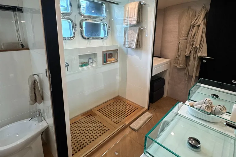 Deea II Yacht Photos Pics Luxurious bathroom on 2009 Cerri Cantieri Navali 102 yacht with glass sinks and wooden shower floor.