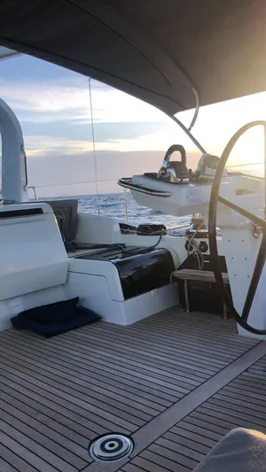  Yacht Photos Pics Luxury Jeanneau 64 yacht deck, 2021 model, with elegant seating and steering wheel at sunset.
