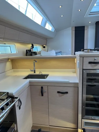  Yacht Photos Pics Modern kitchen interior of 2021 Jeanneau 64 yacht with sleek cabinetry and appliances.