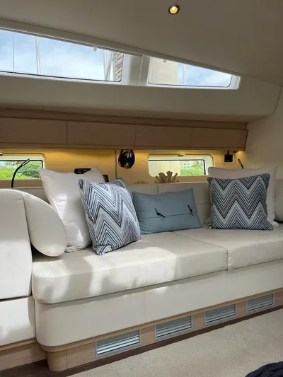  Yacht Photos Pics Luxurious interior of a 2021 Jeanneau 64 yacht with elegant cushions and natural light.