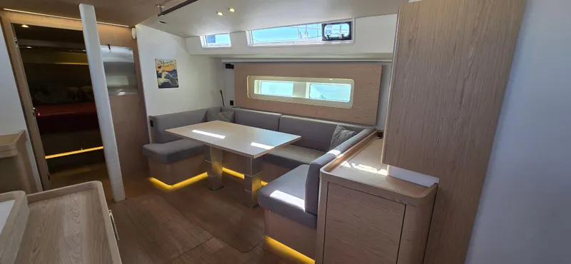 Wildflower Yacht Photos Pics Modern interior of 2021 Beneteau Oceanis Yacht 54 with sleek dining area and ambient lighting.