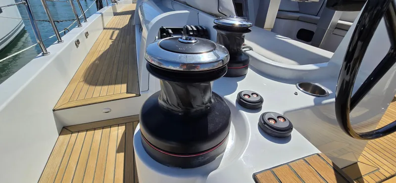 Wildflower Yacht Photos Pics 2021 Beneteau Oceanis Yacht 54 deck with winches and steering wheel, showcasing teak flooring.