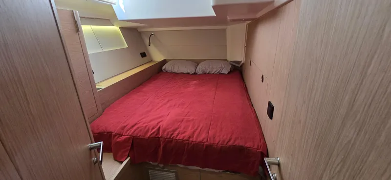 Wildflower Yacht Photos Pics Cozy cabin interior of 2021 Beneteau Oceanis Yacht 54 with red bedding.