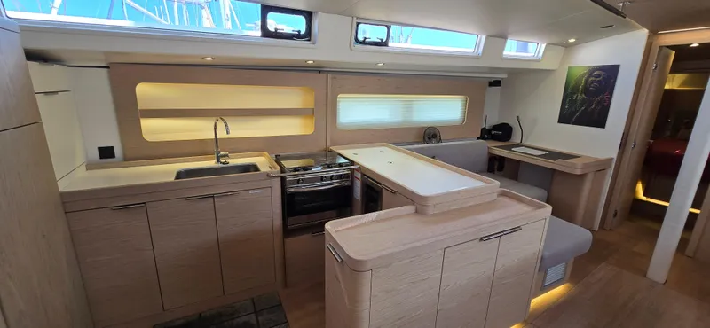 Wildflower Yacht Photos Pics Modern interior of 2021 Beneteau Oceanis Yacht 54 with sleek kitchen and dining area.