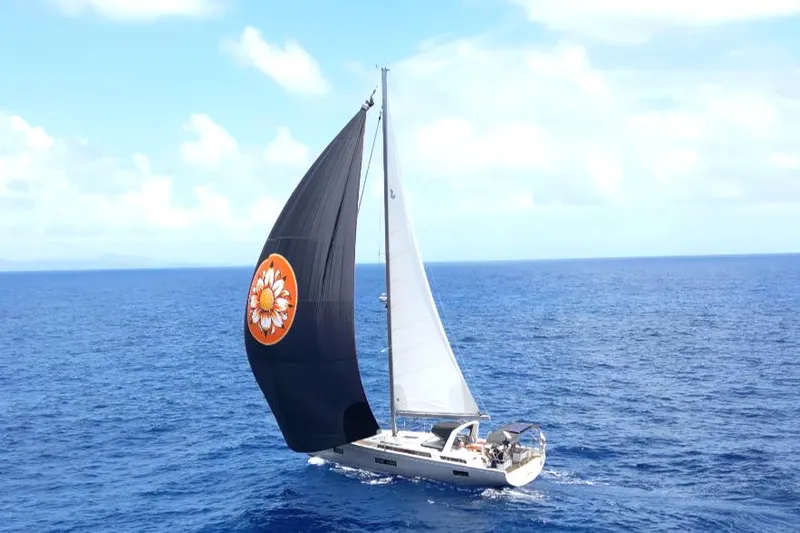 Wildflower Yacht Photos Pics 2021 Beneteau Oceanis Yacht 54 sailing on open sea with distinctive black sail.