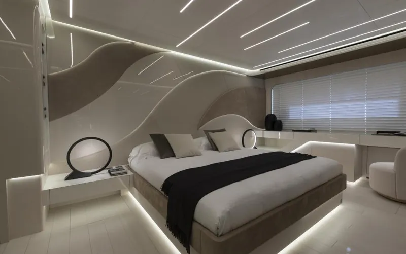  Yacht Photos Pics Luxurious bedroom interior of 2022 Mangusta 165 REV yacht, featuring modern design and ambient lighting.