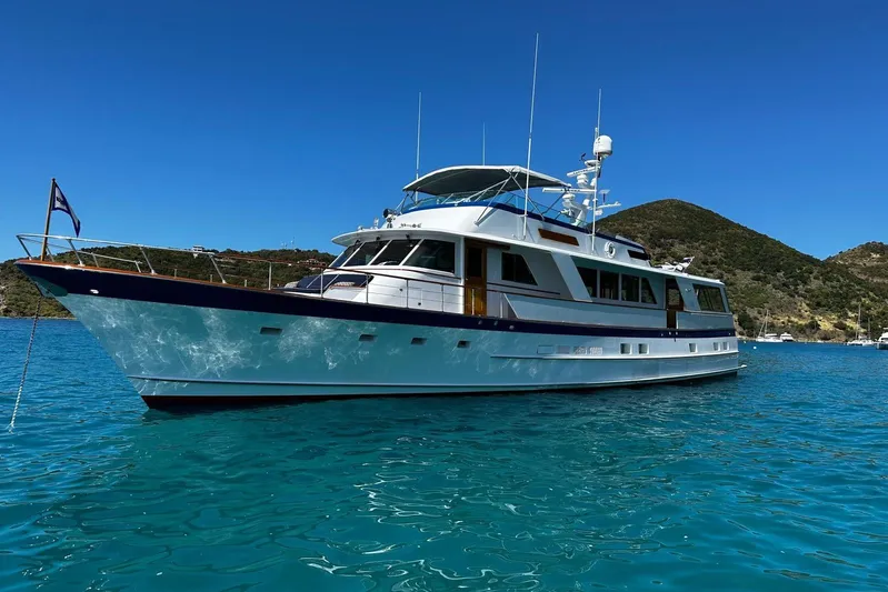 Capricho Yacht Photos Pics 1987 Burger Motoryacht on clear blue water with scenic hillside background.