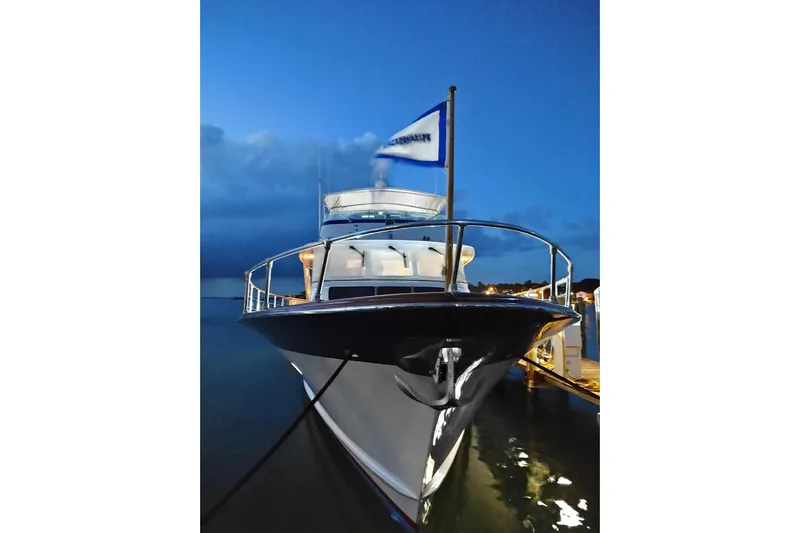 Capricho Yacht Photos Pics 1987 Burger Motoryacht docked at night, illuminated against a deep blue sky.