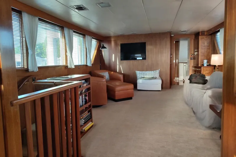 Capricho Yacht Photos Pics Luxurious 1987 Burger Motoryacht interior with cozy seating, wood paneling, and large windows.