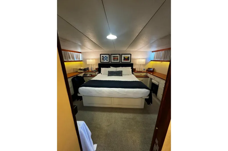 Capricho Yacht Photos Pics Luxurious bedroom interior of 1987 Burger Motoryacht with cozy bed and elegant decor.