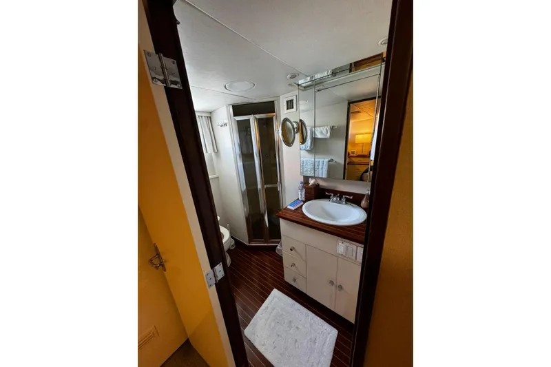 Capricho Yacht Photos Pics Bathroom interior of a 1987 Burger Motoryacht with sink, mirror, and shower.