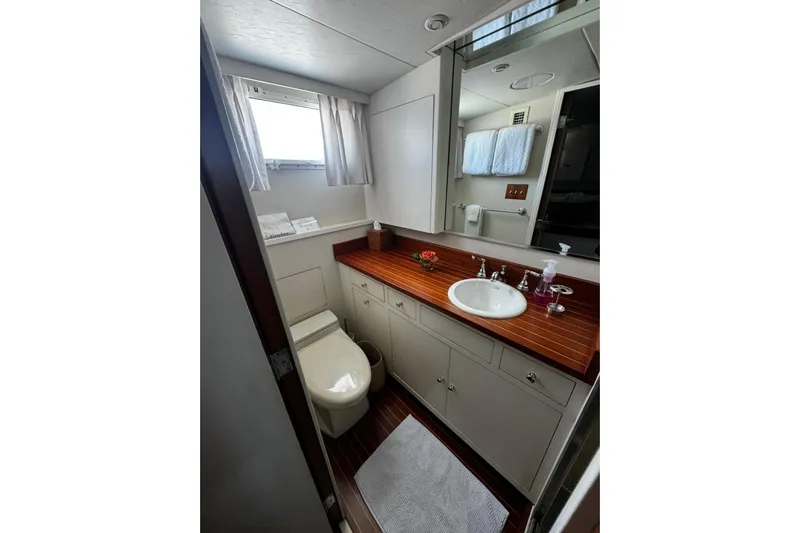 Capricho Yacht Photos Pics Luxurious bathroom in a 1987 Burger Motoryacht with wooden countertop and modern fixtures.