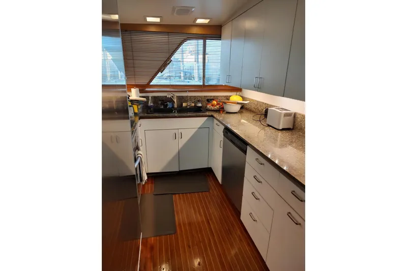 Capricho Yacht Photos Pics 1987 Burger Motoryacht kitchen with modern appliances, granite countertops, and wooden flooring.