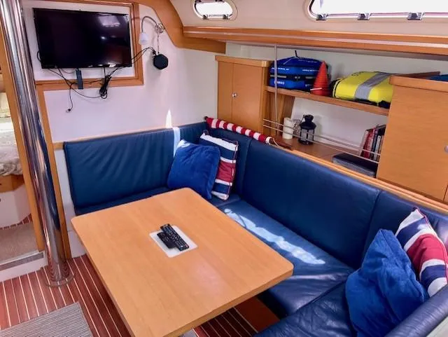 Valanta Yacht Photos Pics Cozy interior of 2007 Hanse 400 yacht with blue seating and wooden table.