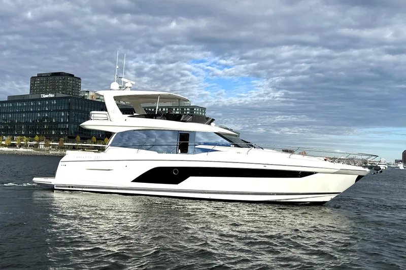 Highland Patriot Yacht Photos Pics 2023 Prestige 590 yacht cruising on a river with cityscape background.