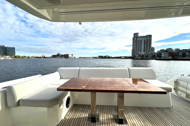 Highland Patriot Yacht Photos Pics Luxury yacht Prestige 590, 2023 model, with elegant deck seating and waterfront view.