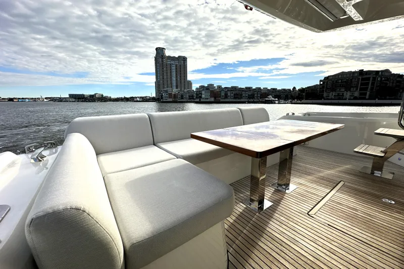 Highland Patriot Yacht Photos Pics Luxurious 2023 Prestige 590 yacht deck with elegant seating and scenic waterfront view.