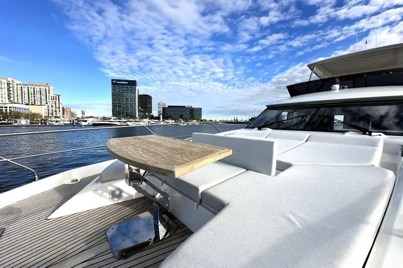 Highland Patriot Yacht Photos Pics Luxurious 2023 Prestige 590 yacht with elegant deck, city skyline in background.