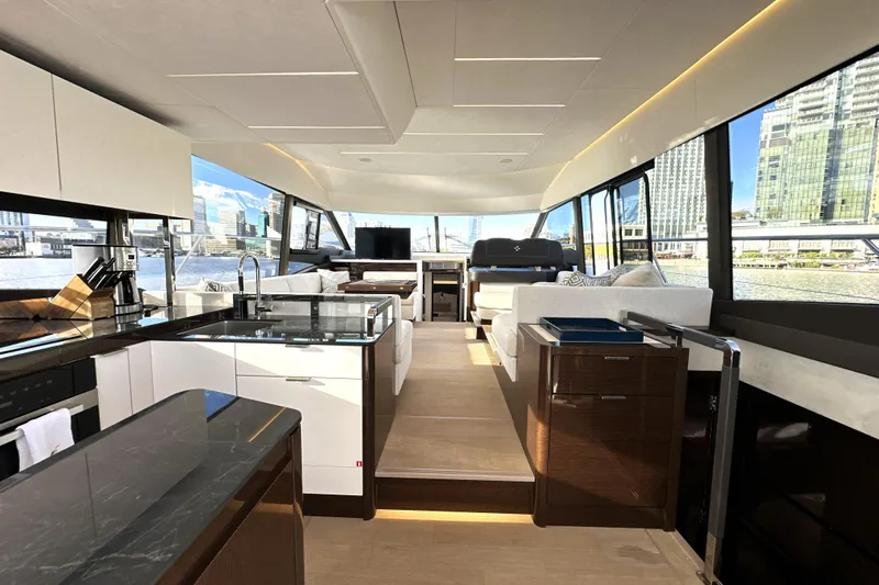 Highland Patriot Yacht Photos Pics Luxurious interior of 2023 Prestige 590 yacht with modern kitchen and panoramic windows.