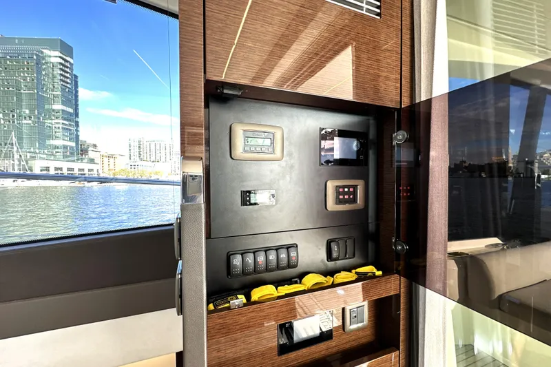 Highland Patriot Yacht Photos Pics Control panel inside 2023 Prestige 590 yacht with cityscape view through window.