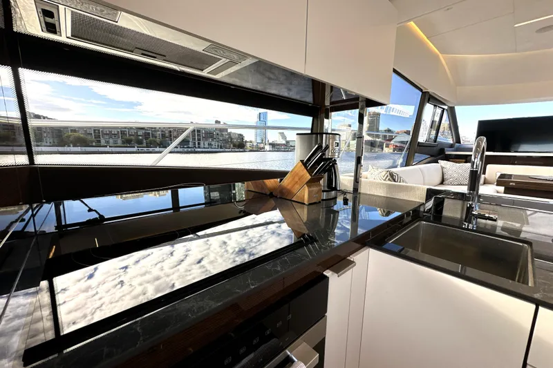 Highland Patriot Yacht Photos Pics Luxurious interior of 2023 Prestige 590 yacht with modern kitchen and scenic views.