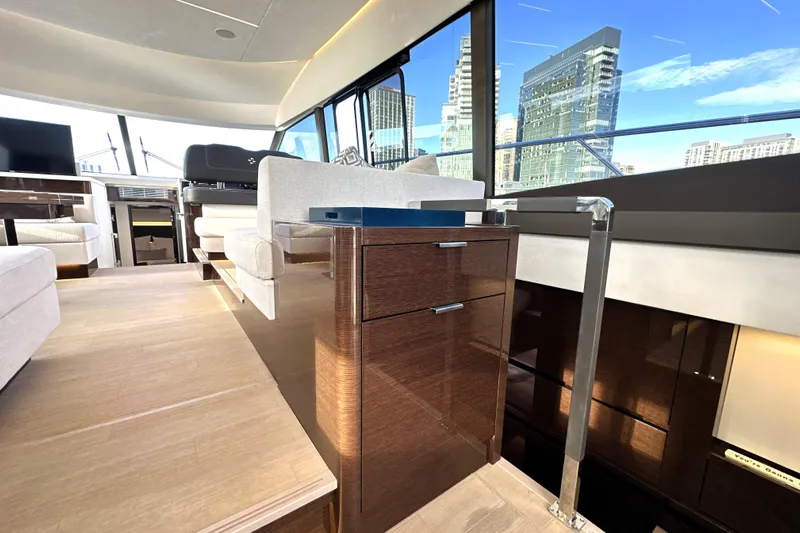 Highland Patriot Yacht Photos Pics Luxurious interior of 2023 Prestige 590 yacht with modern furnishings and cityscape view.