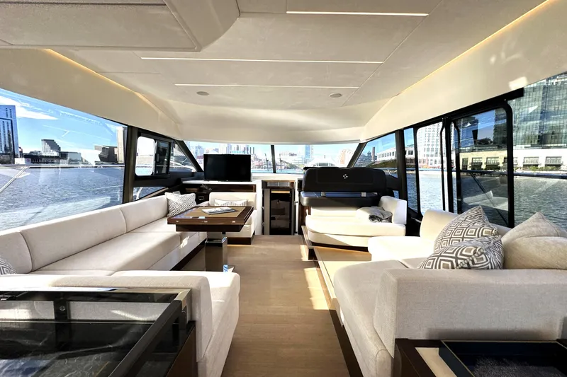 Highland Patriot Yacht Photos Pics Luxurious interior of 2023 Prestige 590 yacht with panoramic windows and elegant seating.