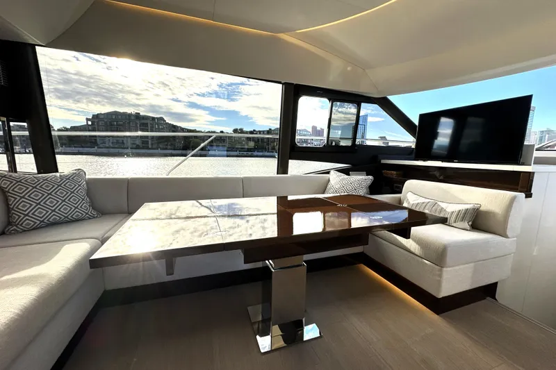 Highland Patriot Yacht Photos Pics Luxurious interior of 2023 Prestige 590 yacht with elegant seating and waterfront view.