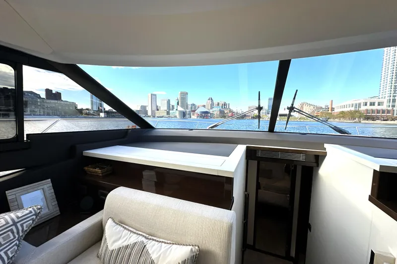 Highland Patriot Yacht Photos Pics Interior view of 2023 Prestige 590 yacht with cityscape through large windows.