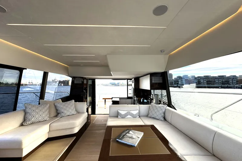 Highland Patriot Yacht Photos Pics Luxurious interior of 2023 Prestige 590 yacht with elegant seating and waterfront views.