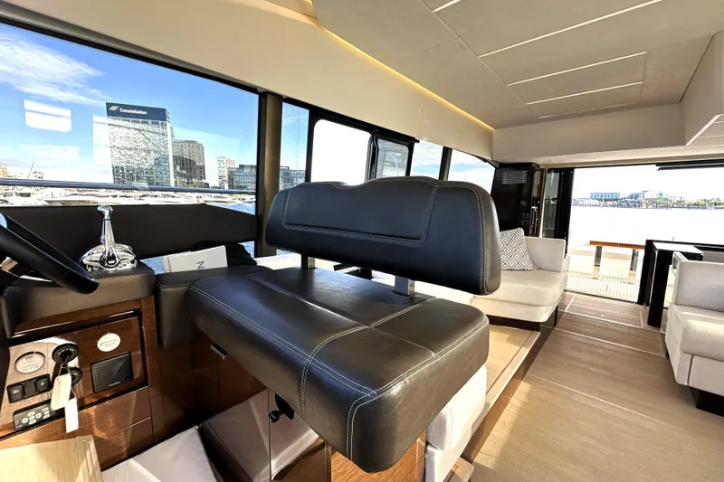 Highland Patriot Yacht Photos Pics Luxurious interior of 2023 Prestige 590 yacht with modern seating and panoramic windows.