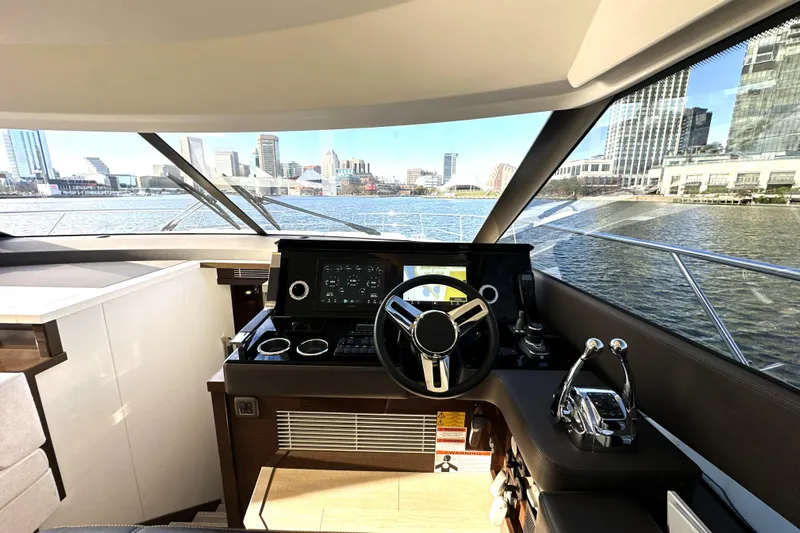 Highland Patriot Yacht Photos Pics Luxurious 2023 Prestige 590 yacht helm with city skyline view through large windows.