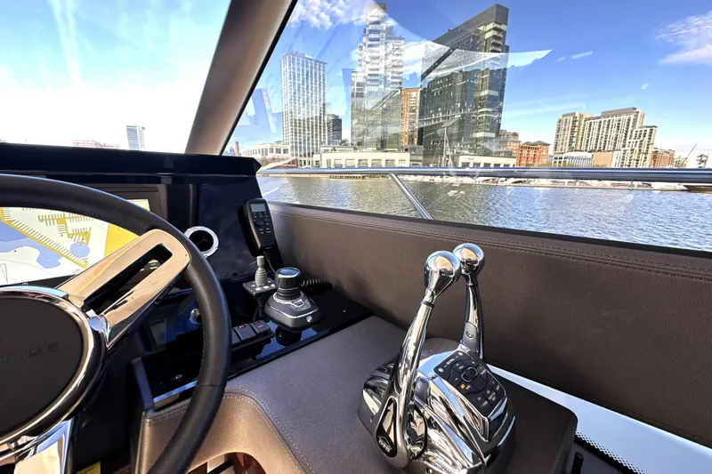 Highland Patriot Yacht Photos Pics Interior view of 2023 Prestige 590 yacht helm with cityscape in background.