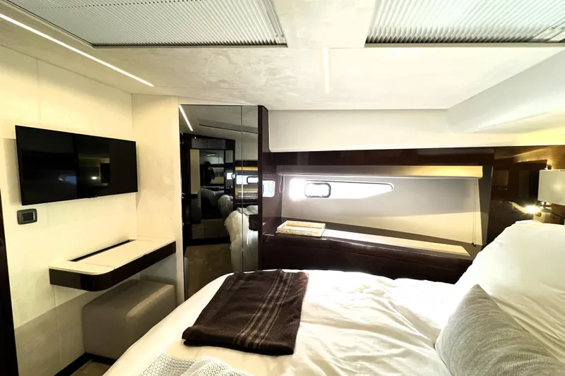 Highland Patriot Yacht Photos Pics Luxurious interior of 2023 Prestige 590 yacht bedroom with modern decor and natural lighting.