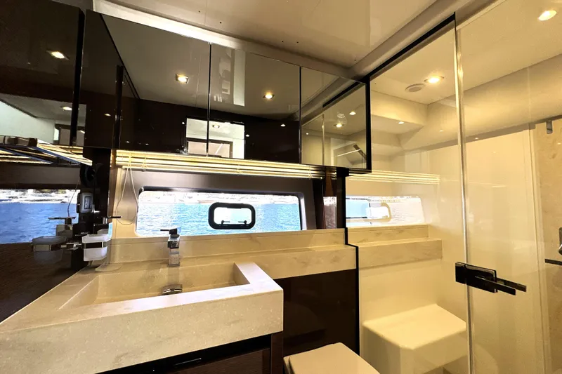 Highland Patriot Yacht Photos Pics Luxurious bathroom interior of 2023 Prestige 590 yacht with modern fixtures and sea view.