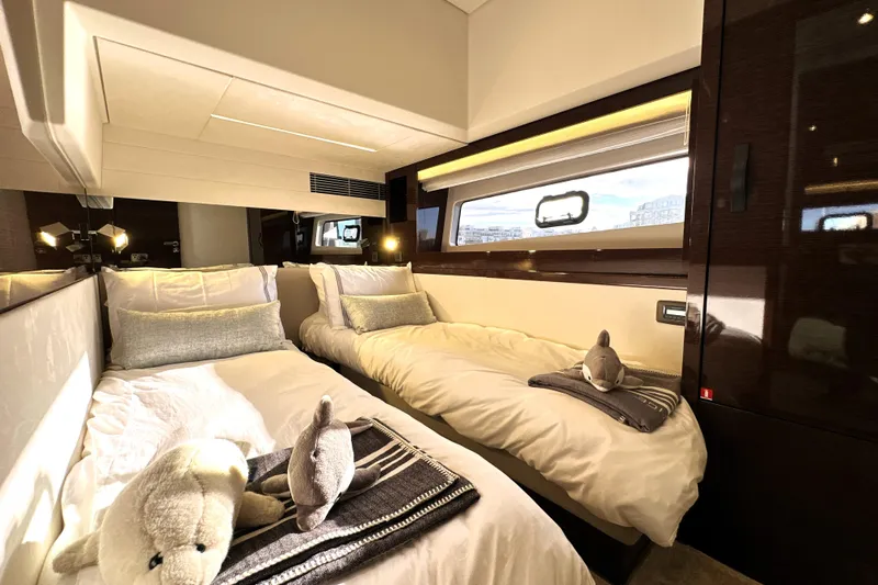 Highland Patriot Yacht Photos Pics Luxurious twin cabin interior on 2023 Prestige 590 yacht, featuring plush bedding and elegant decor.